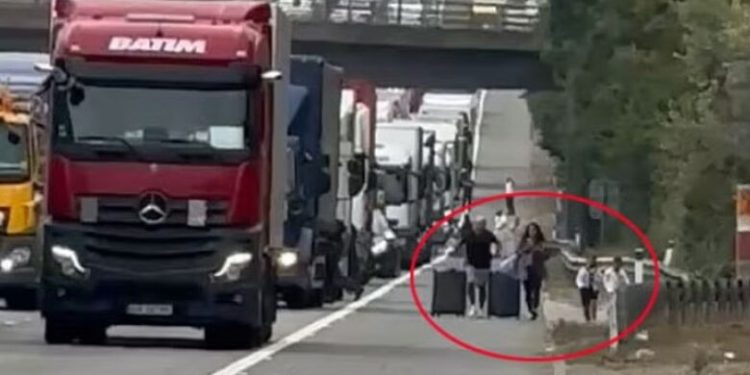 Çifti anglez me dy fëmijë braktis taksinë dhe ecin përgjatë autostradës për të kapur fluturimin me avion për në Greqi