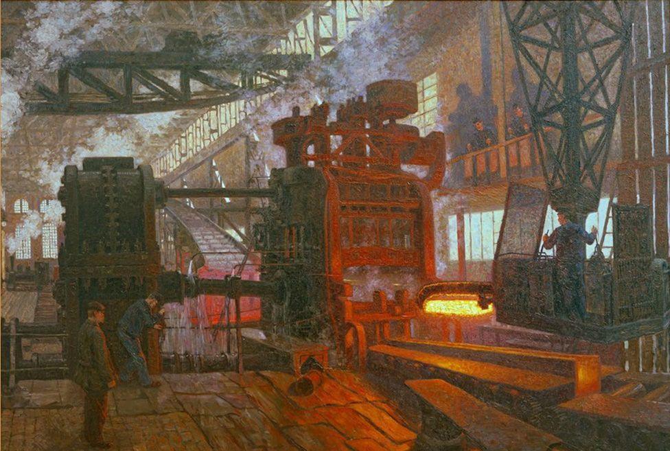 Piktura “Eisenwalzwerk” nga artisti Hans Baluschek tregon një skenë industriale brenda një fabrike ose fonderie të madhe, me punëtorë që punojnë me makineri të rënda. Një makinë shtypi ose farkëtimi masive shkëlqen me nxehtësi të fortë ndërsa përpunon metalin e nxehtë. Hapësira është e mbushur me tym dhe avull, me dritë natyrale që rrjedh përmes dritareve të larta, duke krijuar një atmosferë dramatike pune intensive dhe aktiviteti industrial.