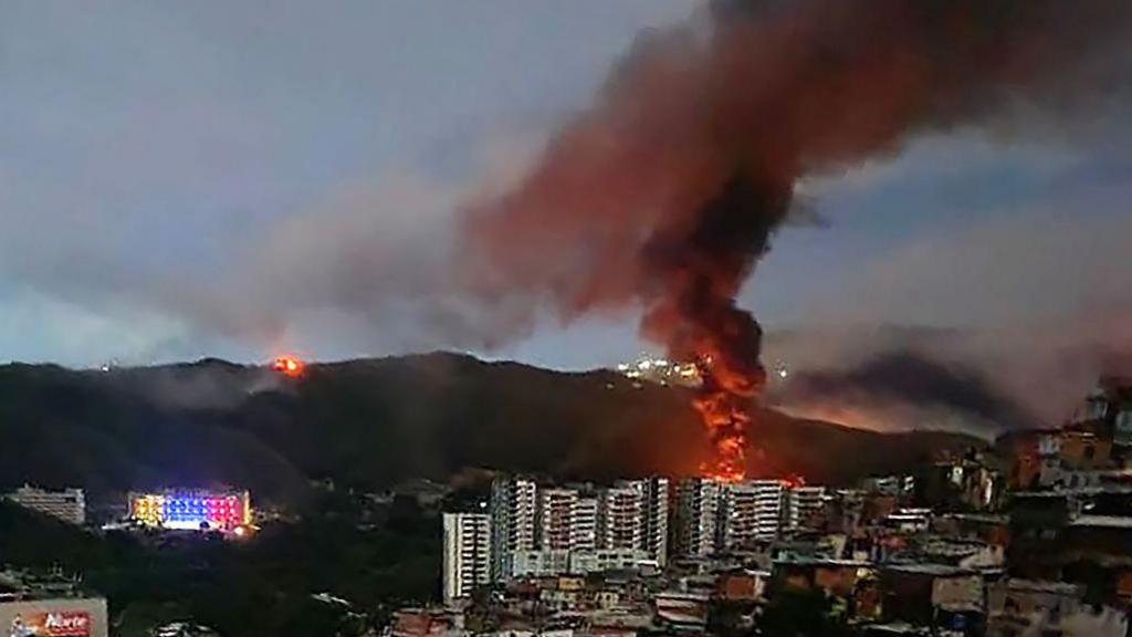 Zjarri në Fuerte Tiuna, kompleksin më të madh ushtarak të Venezuelës, shihet nga larg pas një serie shpërthimesh në Karakas.
