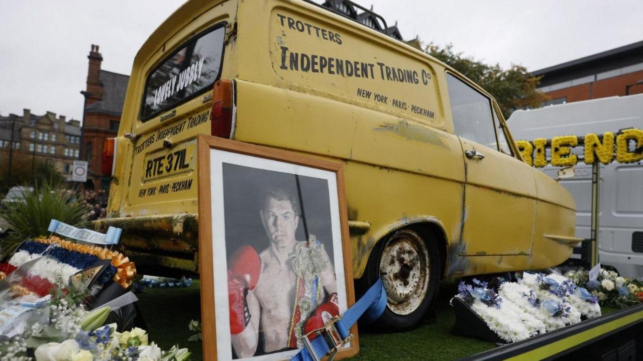 Furgoni i famshëm i verdhë nga filmi "Only Fools And Horses" është në pjesën e pasme të një kamioni. Është i rrethuar nga lule.