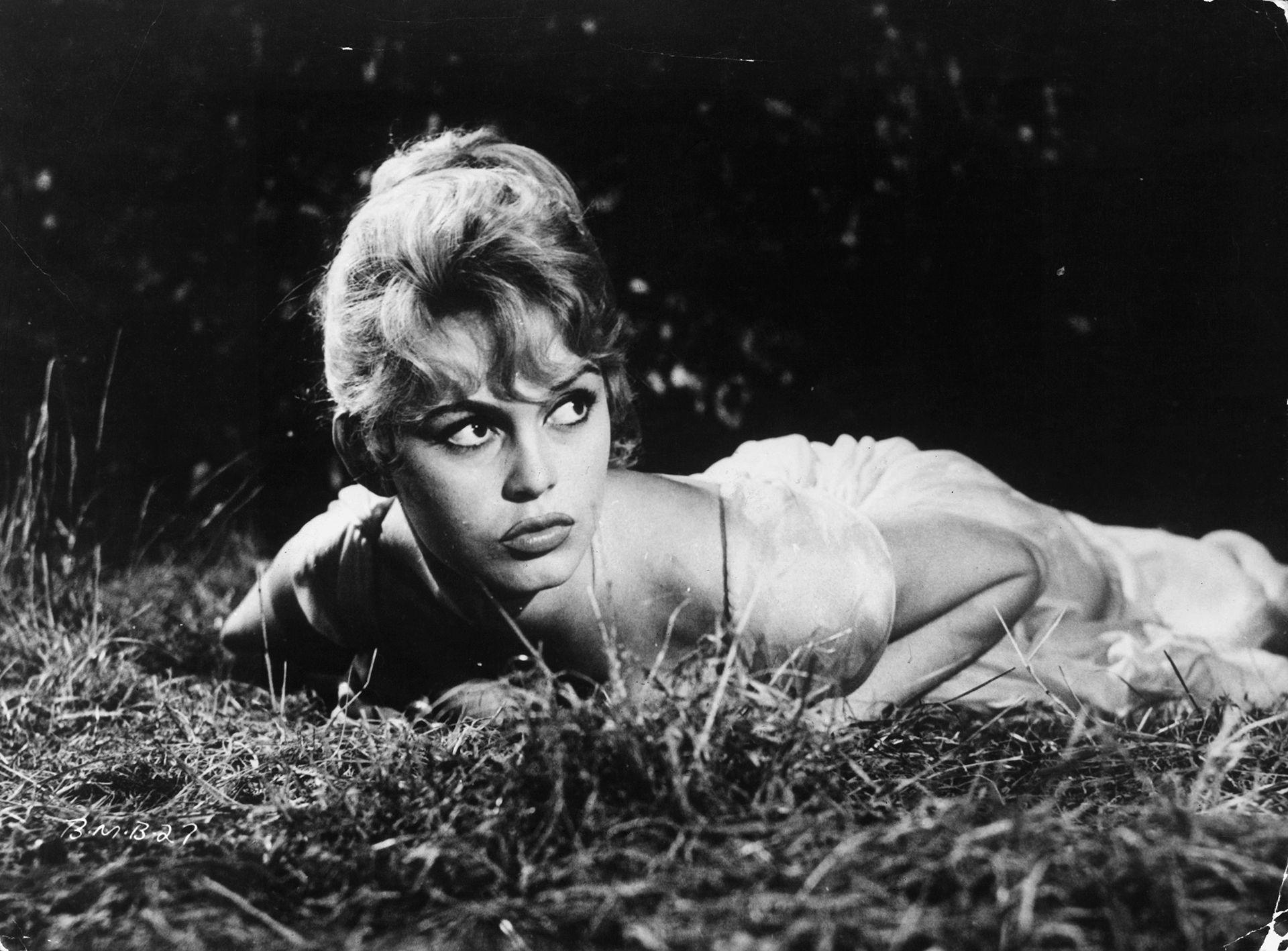 Brigitte Bardot e shtrirë në bar në një fotografi nga filmi "Nusja është shumë e bukur" e vitit 1956.