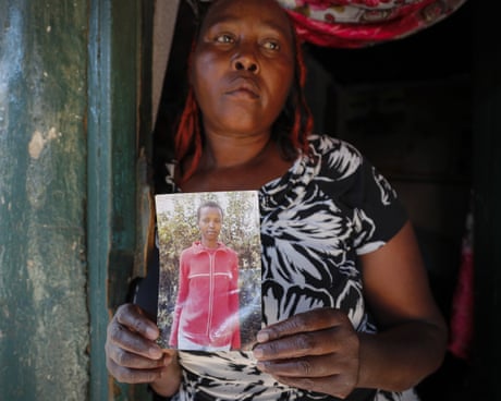 Rose Wanyua Wanjiku, duke qëndruar në një derë, mban foton