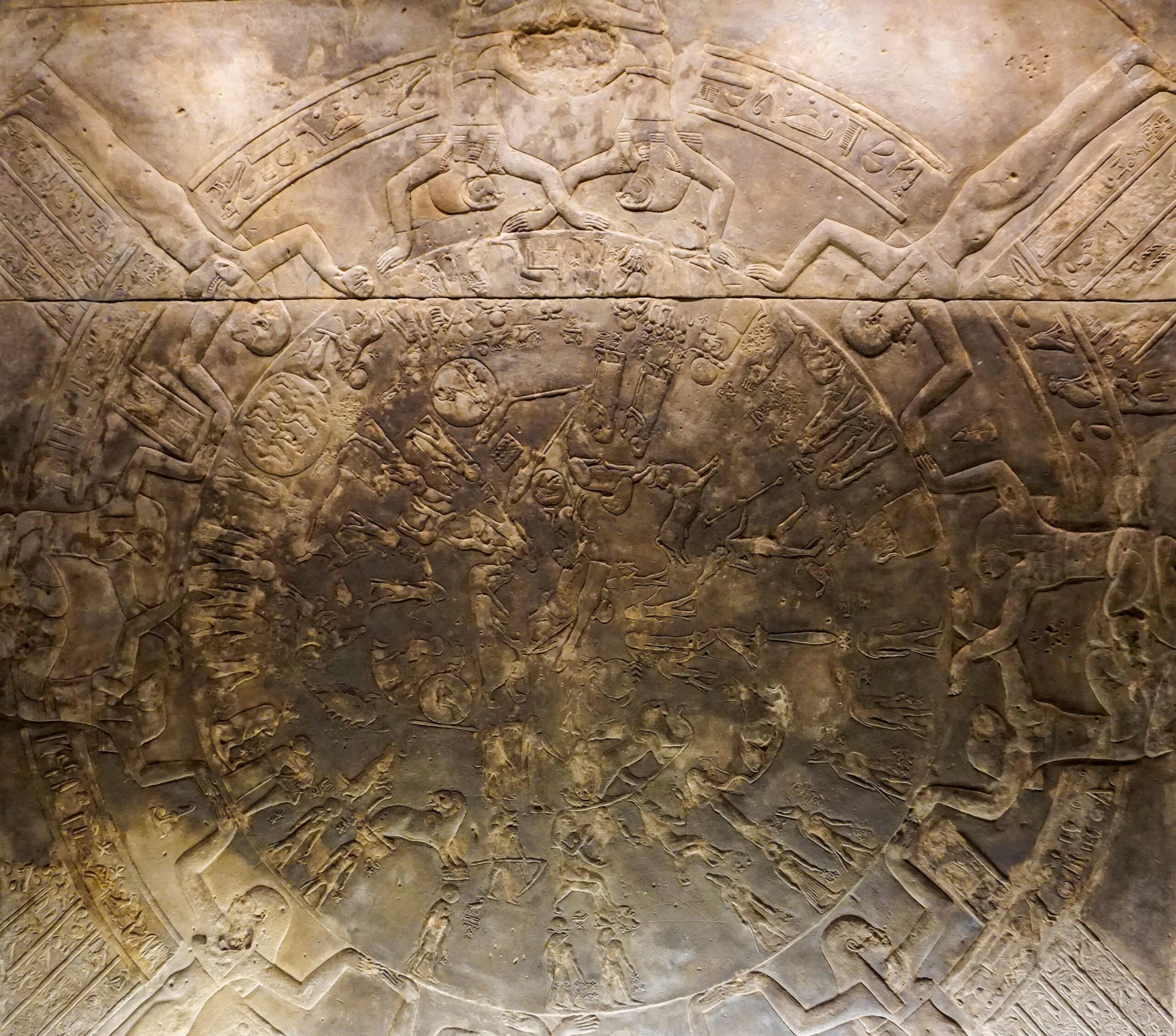 Pamje nga afër e Zodiakut Dendera. Gdhendje të perëndive dhe perëndeshave të Egjiptit të Lashtë, kafshëve dhe hieroglifëve të organizuar në rreth. Materiali i gdhendur ka të ngjarë të ketë qenë fillimisht i bardhë, por është thinjur me kalimin e kohës. Figurat në rreth përfaqësojnë yjësi dhe trupa qiellorë të ndryshëm.