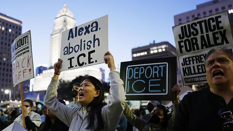 Njerëzit mbajnë pankarta ku shkruhet "Alexa, shfuqizo ICE-në", "Deporto ICE-në" dhe "Drejtësi për Alex-in".
