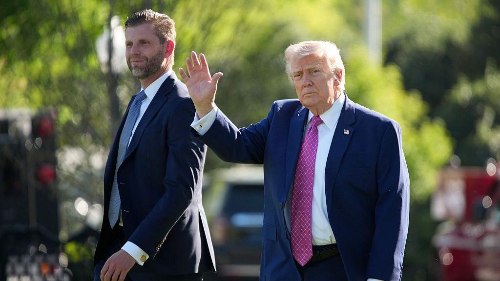 Donald Trump përshëndet me dorë ndërsa ecën përkrah të birit, Eric.