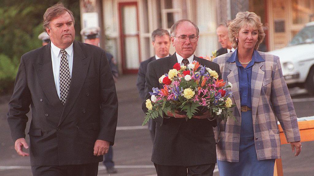 Udhëheqësja e opozitës federale të punës Kim Beazley, kryeministri John Howard dhe udhëheqësja e demokratëve Cheryl Kernot në Port Arthur. John Howard mban një kurorë.