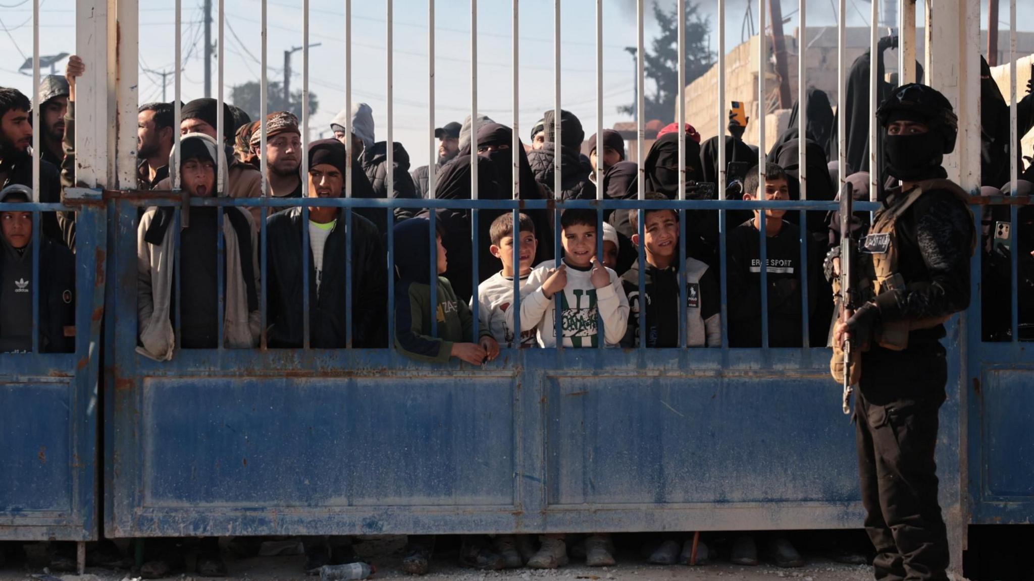 Forcat e sigurisë siriane qëndrojnë përpara portës së kampit al-Hol, pas së cilës qëndrojnë anëtarë të familjeve të të dyshuarve si anëtarë të ISIS-it, në provincën Hassakeh, Siri (21 janar 2026)