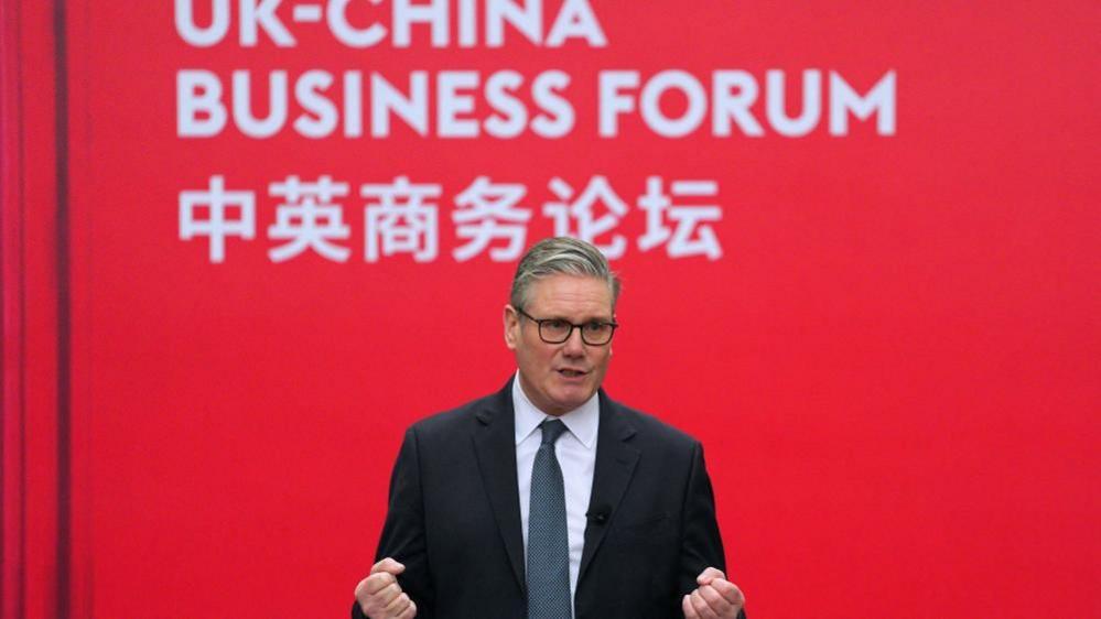 Përpara një sfondi të kuq, Sir Keir Starmer mban një fjalim në një Forum Biznesi Britani-Kinë në Pekin.