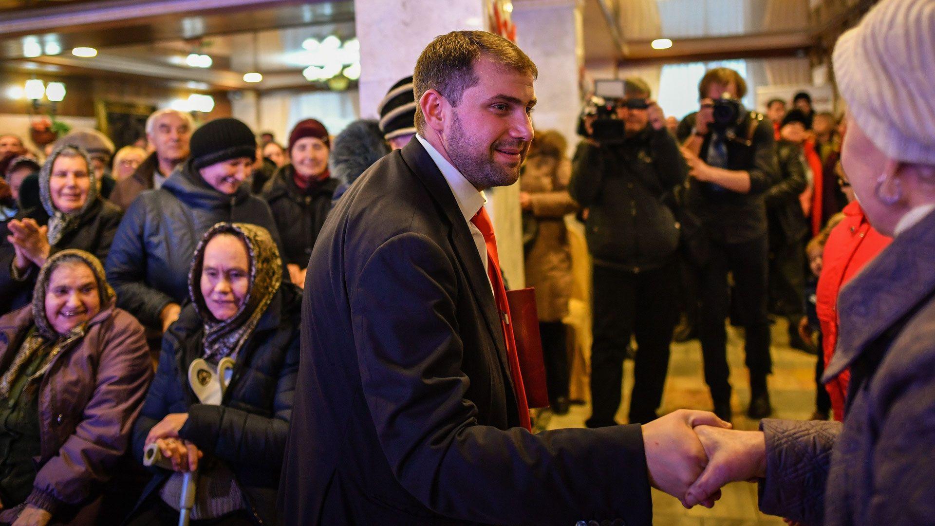 Kandidati parlamentar i Moldavisë, Ilan Shor, biznesmen, udhëheqës i partisë së tij të vetëquajtur dhe kryetar i bashkisë së qytetit Orhei, takohet me mbështetësit gjatë një aktiviteti zgjedhor në qytetin Comrat më 15 shkurt 2019. Ai mban veshur një kostum të errët dhe kravatë të kuqe dhe shtrëngon duart me dikë gjatë fushatës. Disa zonja të moshuara me shami janë në sfond.
