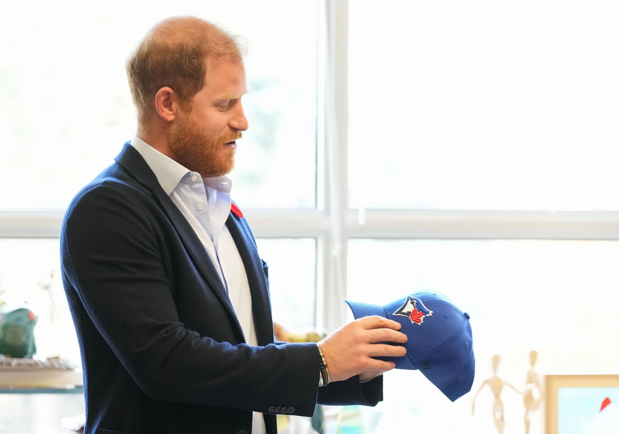 Princi Harry shikon një kapelë të Toronto Blue Jays.
