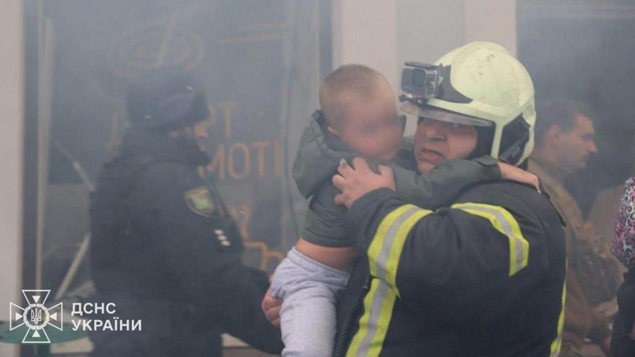 Fedir Uhnenko fotografohet duke shpëtuar një djalë të vogël nga një kopsht fëmijësh në Kharkiv