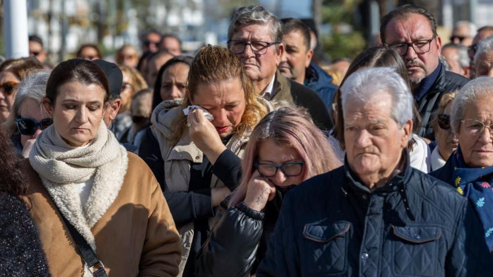 Njerëzit mblidhen për të mbajtur një minutë heshtje në kujtim të viktimave të përplasjes së trenave që ndodhi më 18 janar, në Punta Umbria, Huelva, Spanjë, më 20 janar 2026.