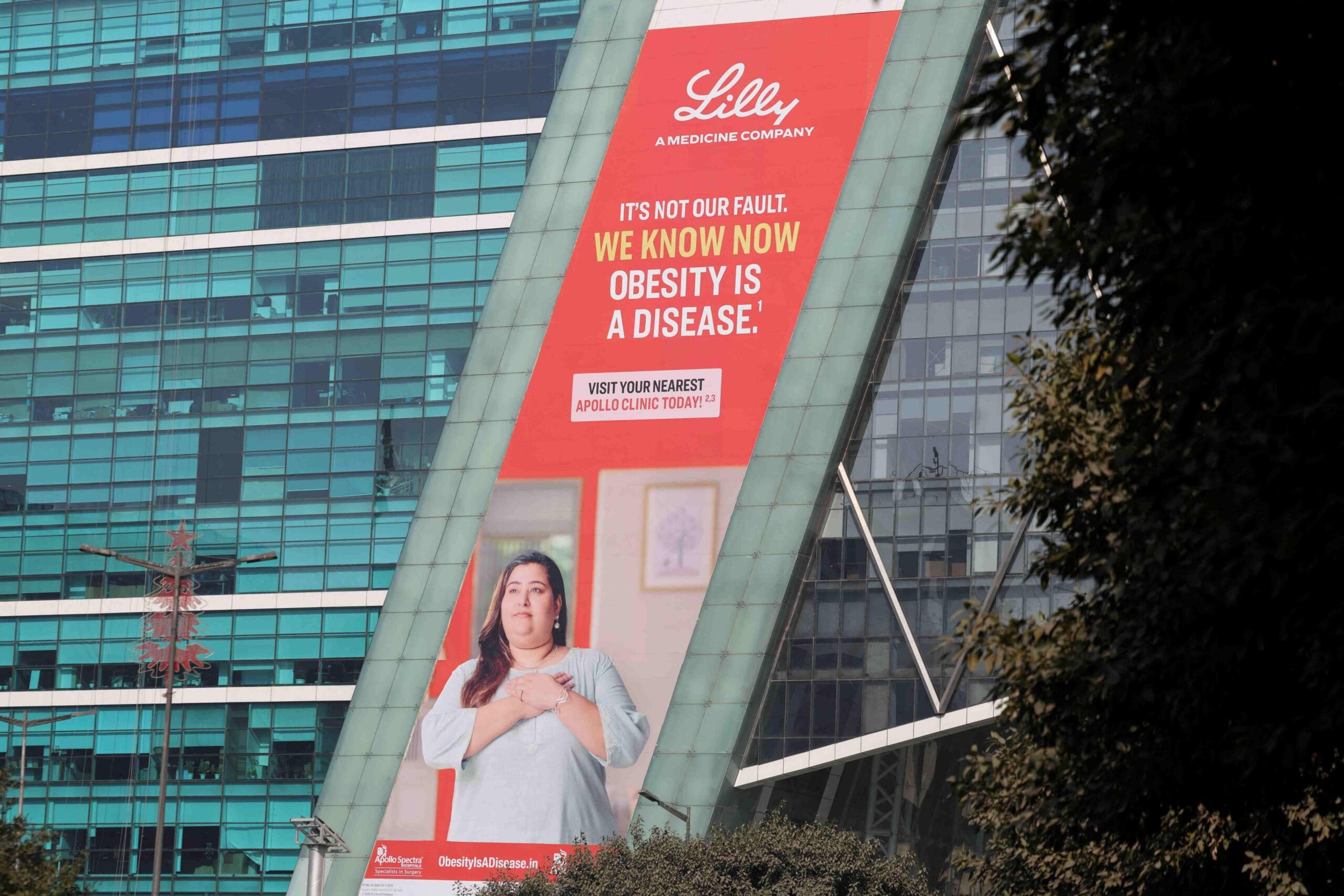 Një koleksion i Eli Lilly në një ndërtesë në Gurugram të Indisë tregon një grua të veshur me një tunikë me duart në zemër. Slogani thotë - "Nuk është faji ynë. Tani e dimë që mbipesha është një sëmundje".