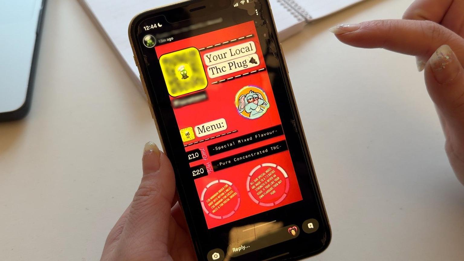 Një pamje nga afër e një telefoni të zi me një reklamë nga Snapchat. Reklama është e kuqe dhe ka një menu të listuar, me çmime 10 dhe 20 paund të dukshme, dhe një fotografi të një lepurushi vizatimor. Në krye shkruan Your Local The Plug.