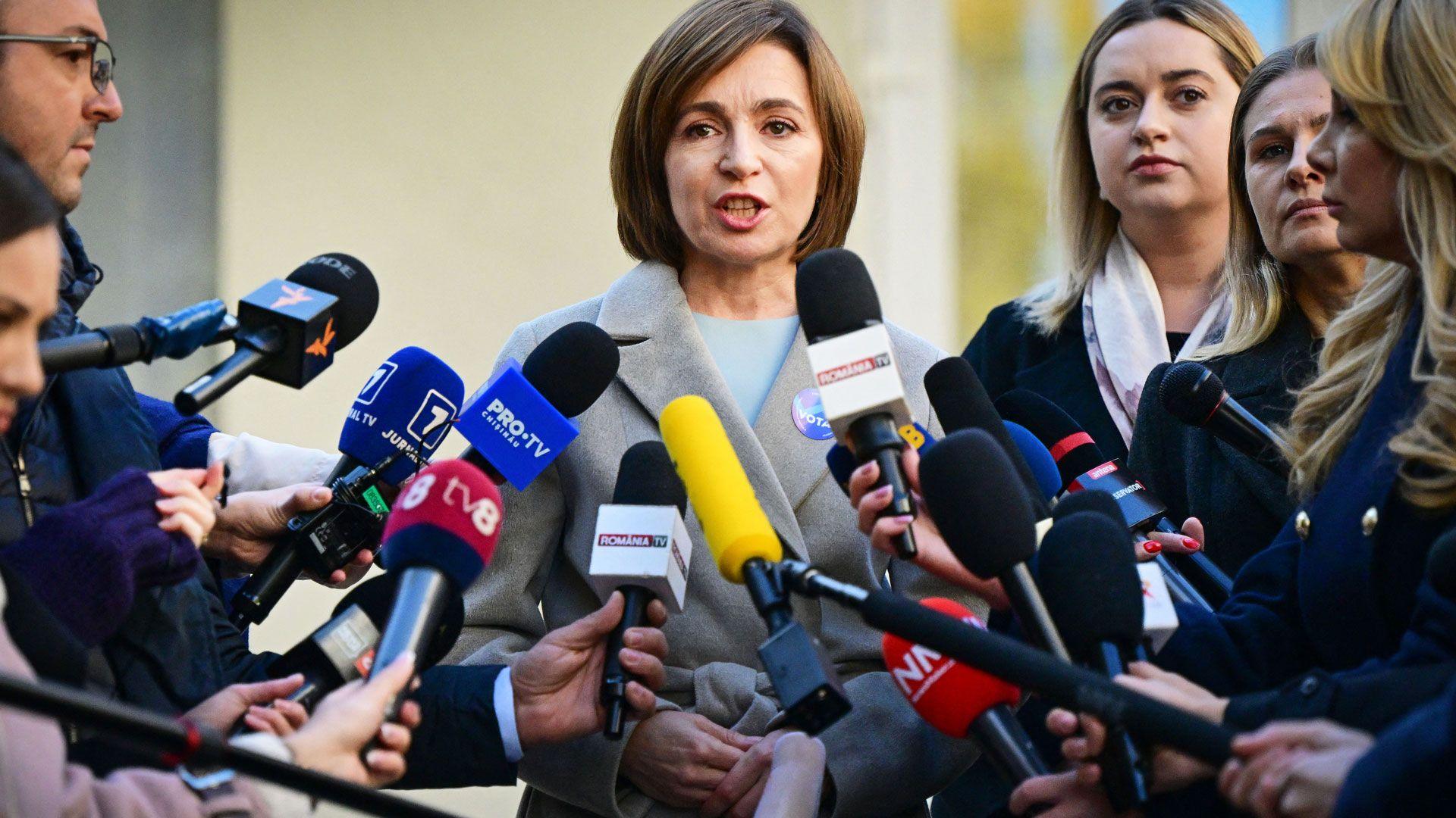 Presidentja e Moldavisë, Maia Sandu (C), u drejtohet mediave pasi votoi për zgjedhjet presidenciale në një qendër votimi në Kishinau më 3 nëntor 2024. Maia Sandu ka flokë të shkurtër ngjyrë kafe dhe të veshur me një pallto elegante gri.
