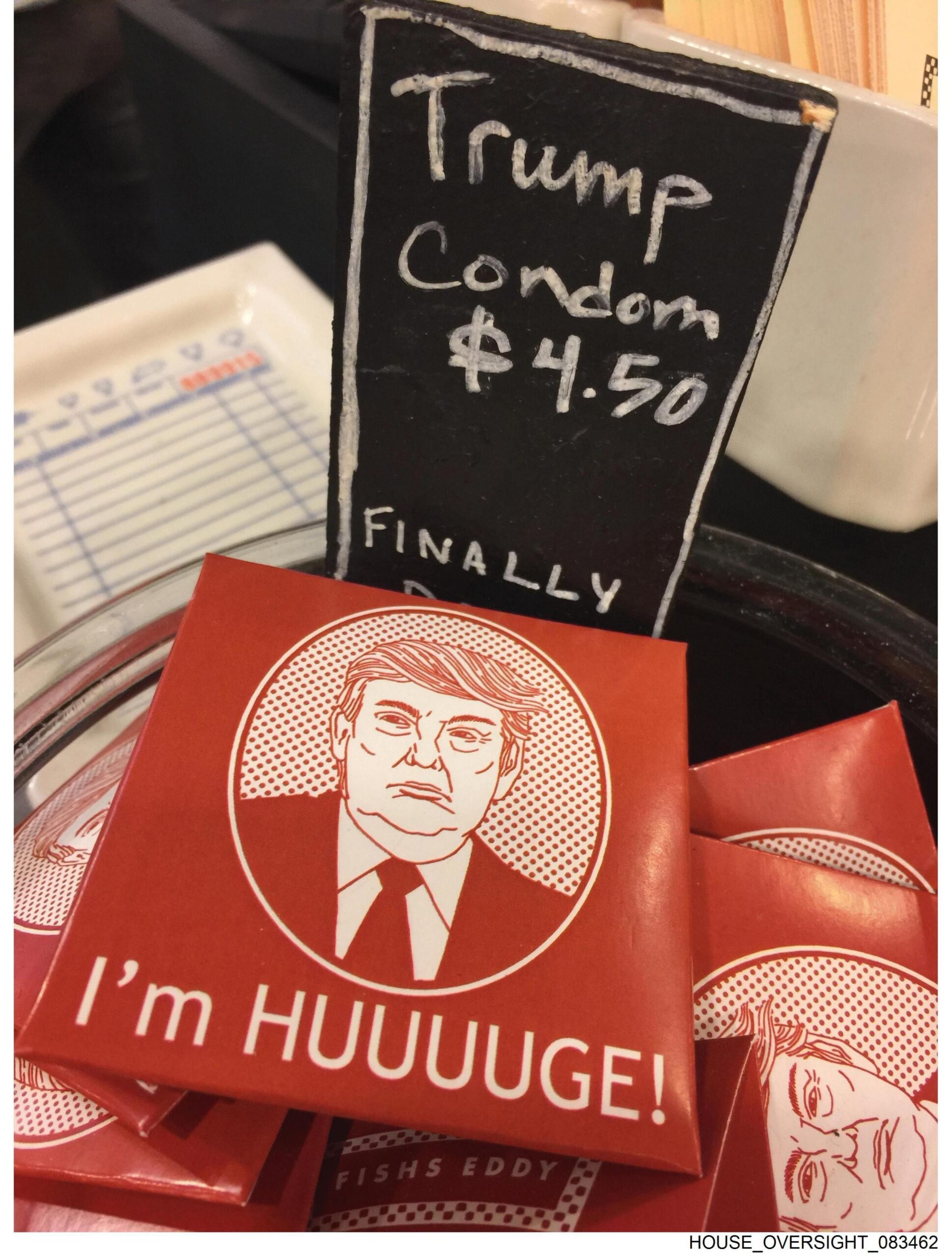 Foto që tregon një ngjashmëri të ilustruar të presidentit në pako të kuqe pranë një shenje që shkruan: "Prezervativi Trump".