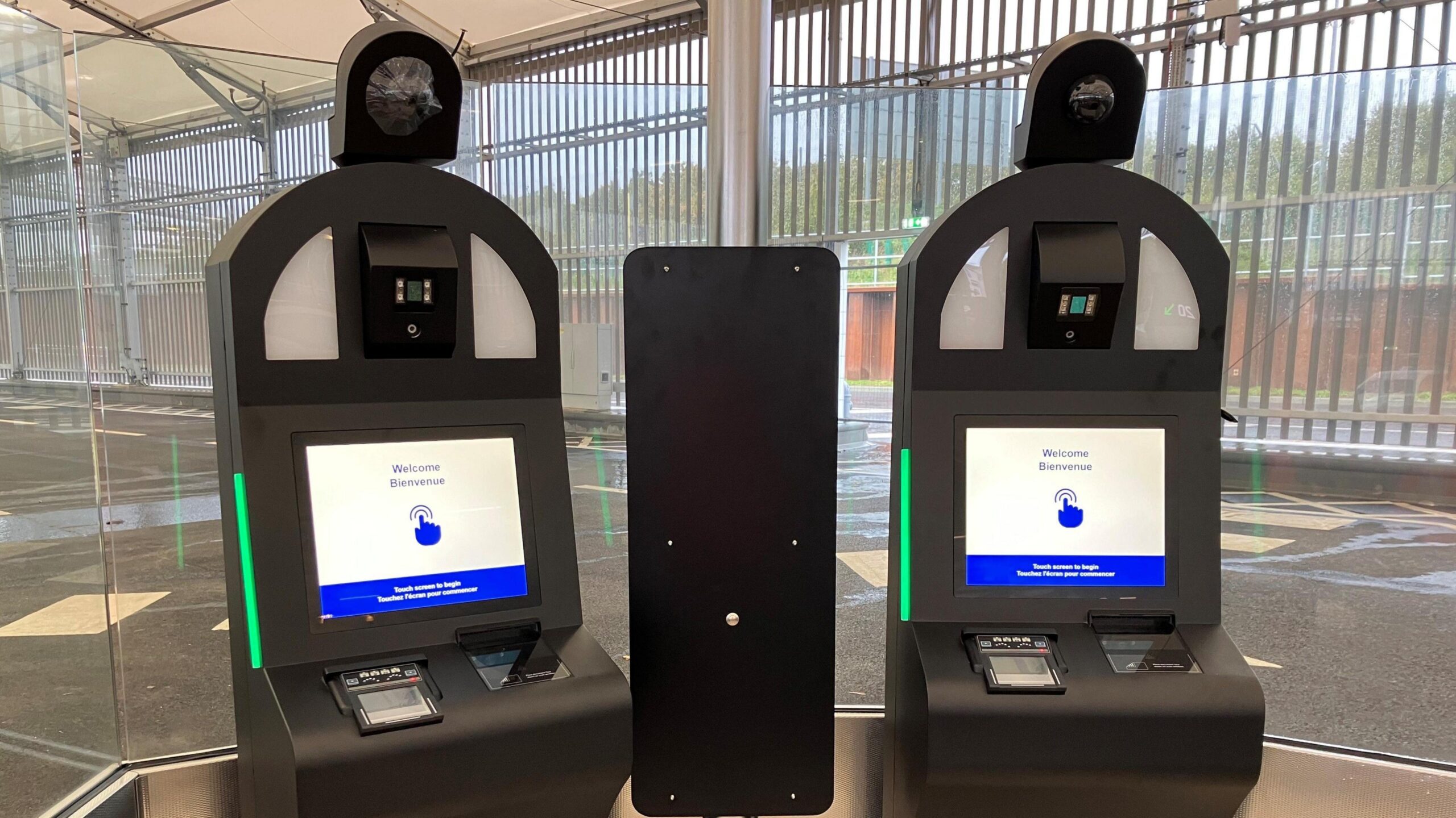 Dy nga kioskat EES të Eurotunnel. Çdo makinë ka një kamera dhe një ekran me prekje ku shkruhet "Mirë se vini/Mirë se vini".