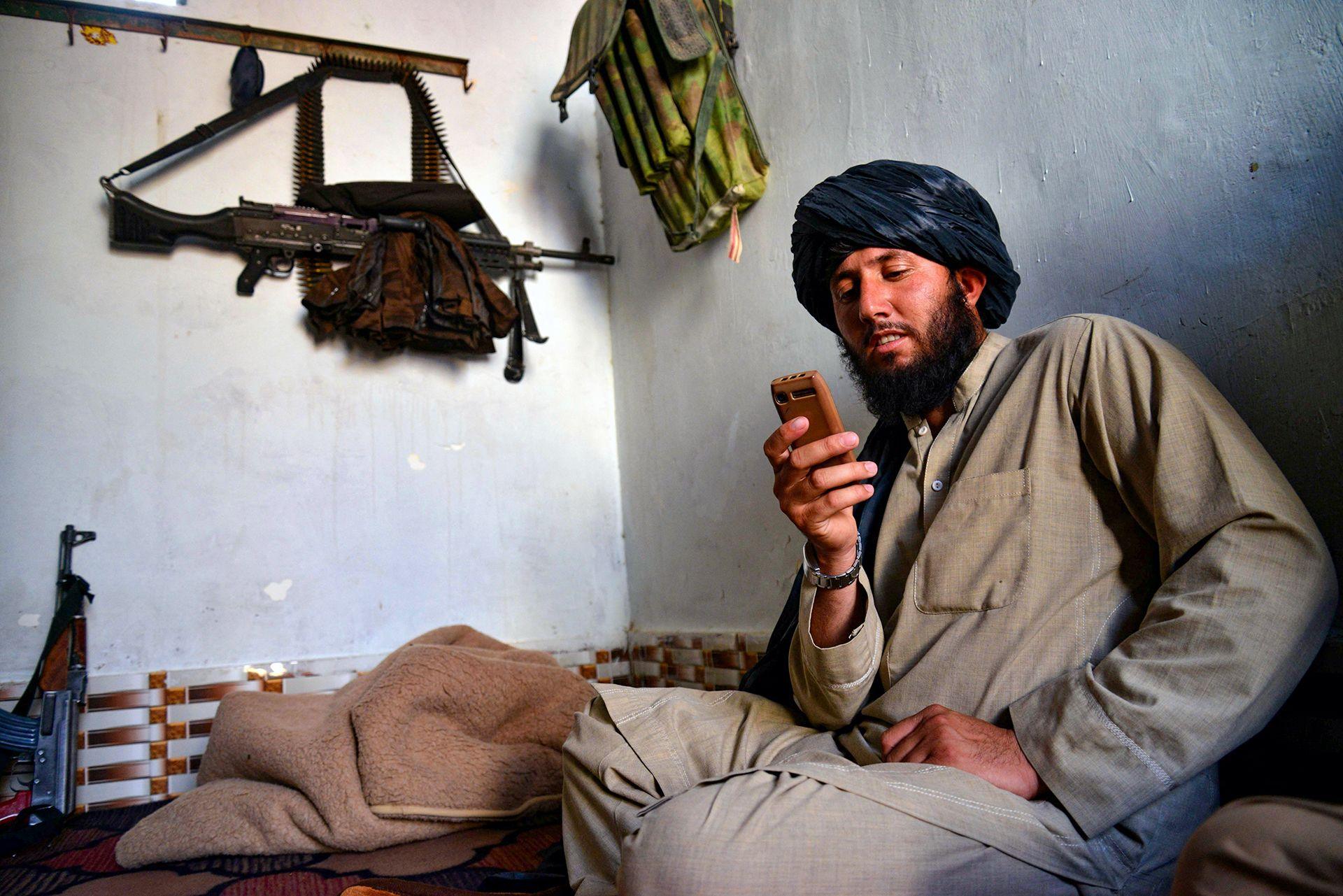 Një personel sigurie i talebanëve përdor një telefon jo-smartfon në Kandahar më 17 qershor 2025. Udhëheqësi suprem i talebanëve, Hibatullah Akhundzada, u kishte bërë thirrje zyrtarëve dhe studiuesve që të zvogëlonin përdorimin e telefonave inteligjentë.
