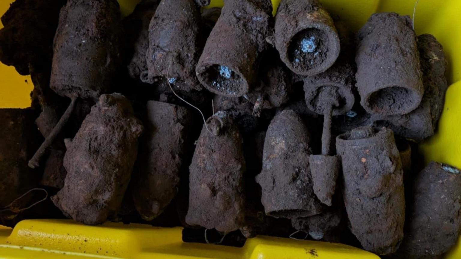 Një kuti e verdhë përmban rreth 20 bomba të Luftës së Dytë Botërore të mbështjella me baltë, por me një ngarkesë ende të dukshme në shumicën e tyre.