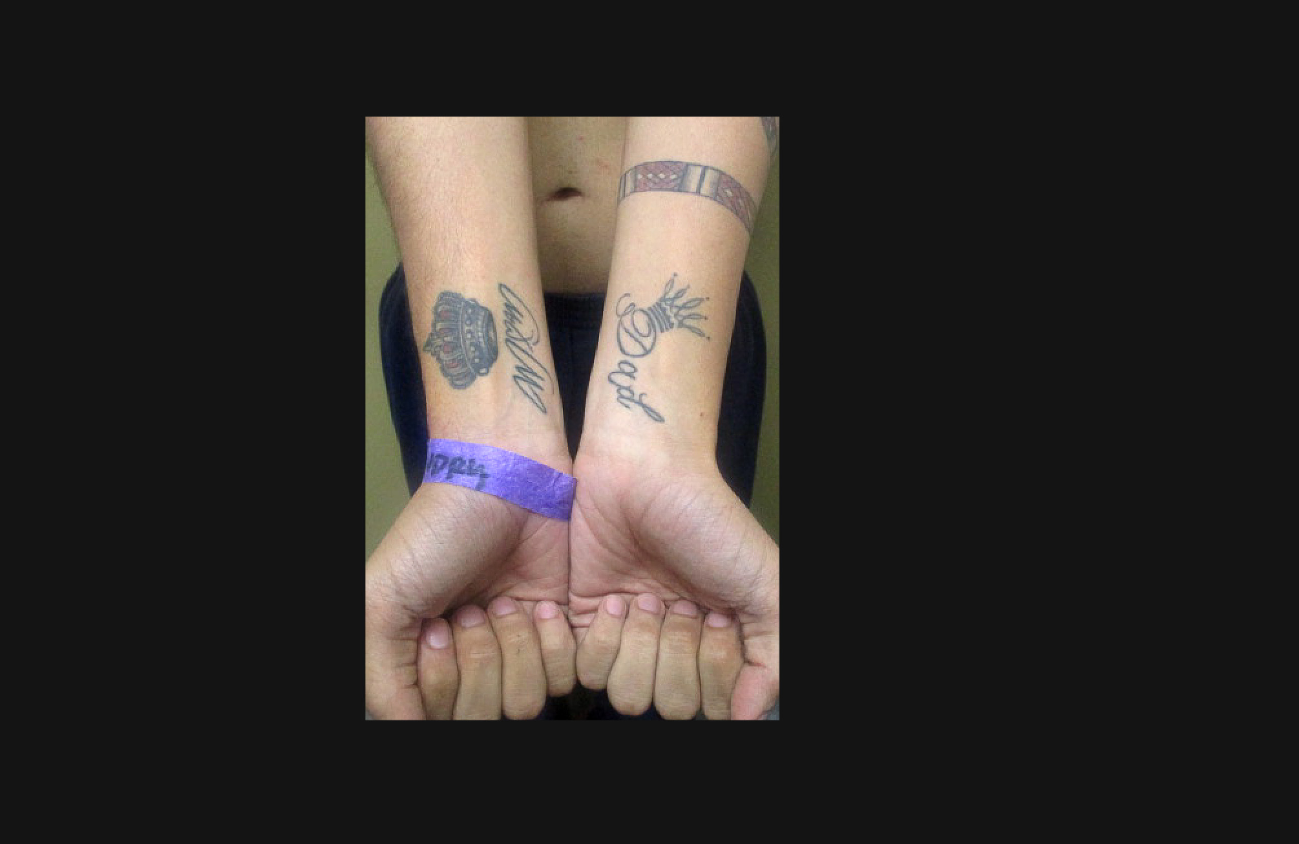 I burgosuri mban kyçet e duarve lart për të treguar tatuazhet në parakrahët e mamasë në njërën krah dhe babait në tjetrën, me nga një kurorë sipër secilës.